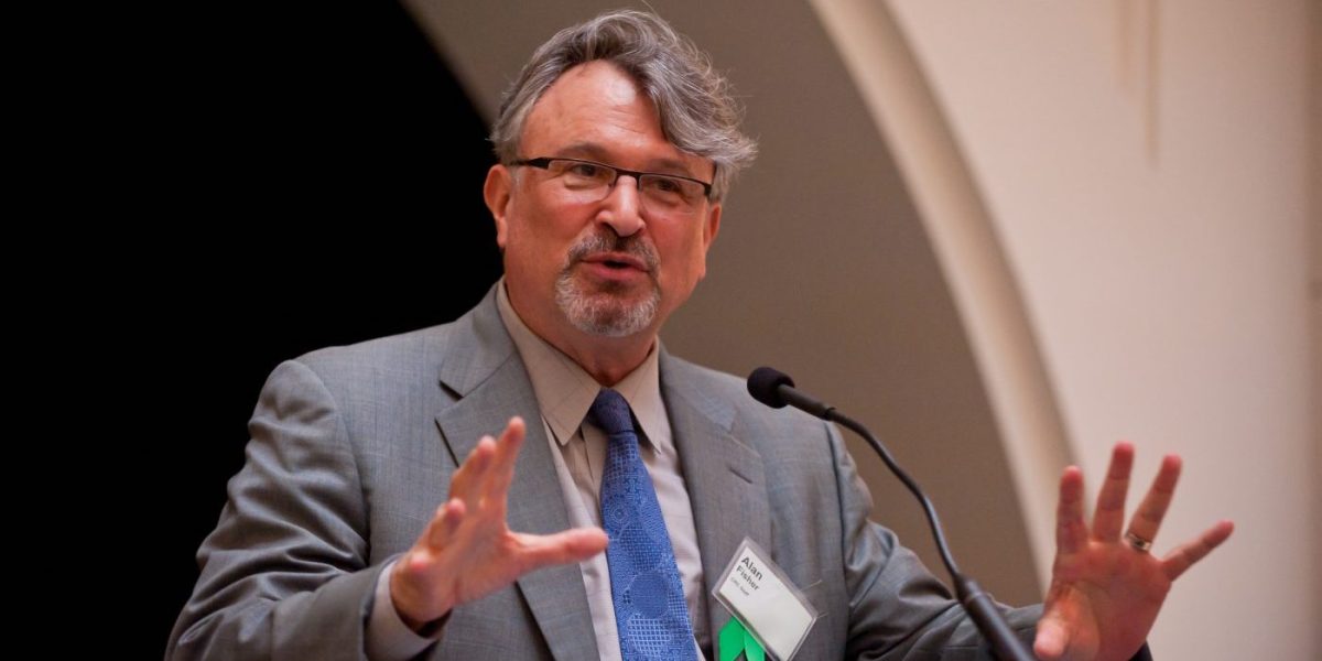 Alan Fisher speaking at a podium